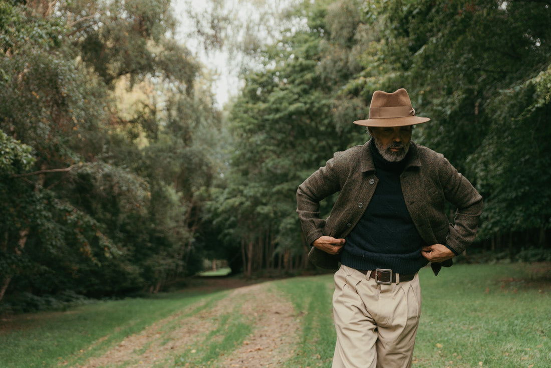 man walking up country road in light brown Goodwood fedora